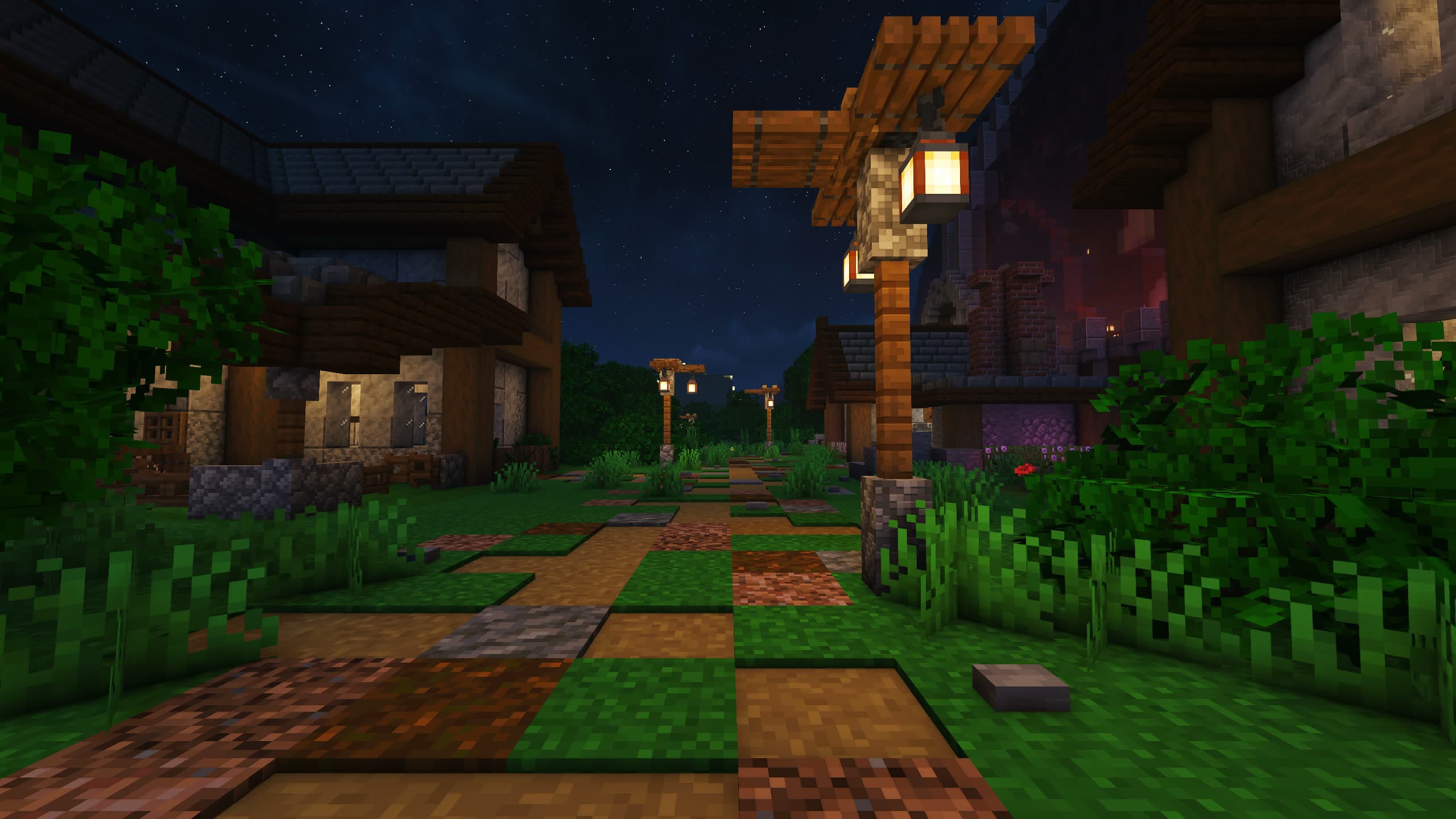A lantern-lit path between houses in the village at night