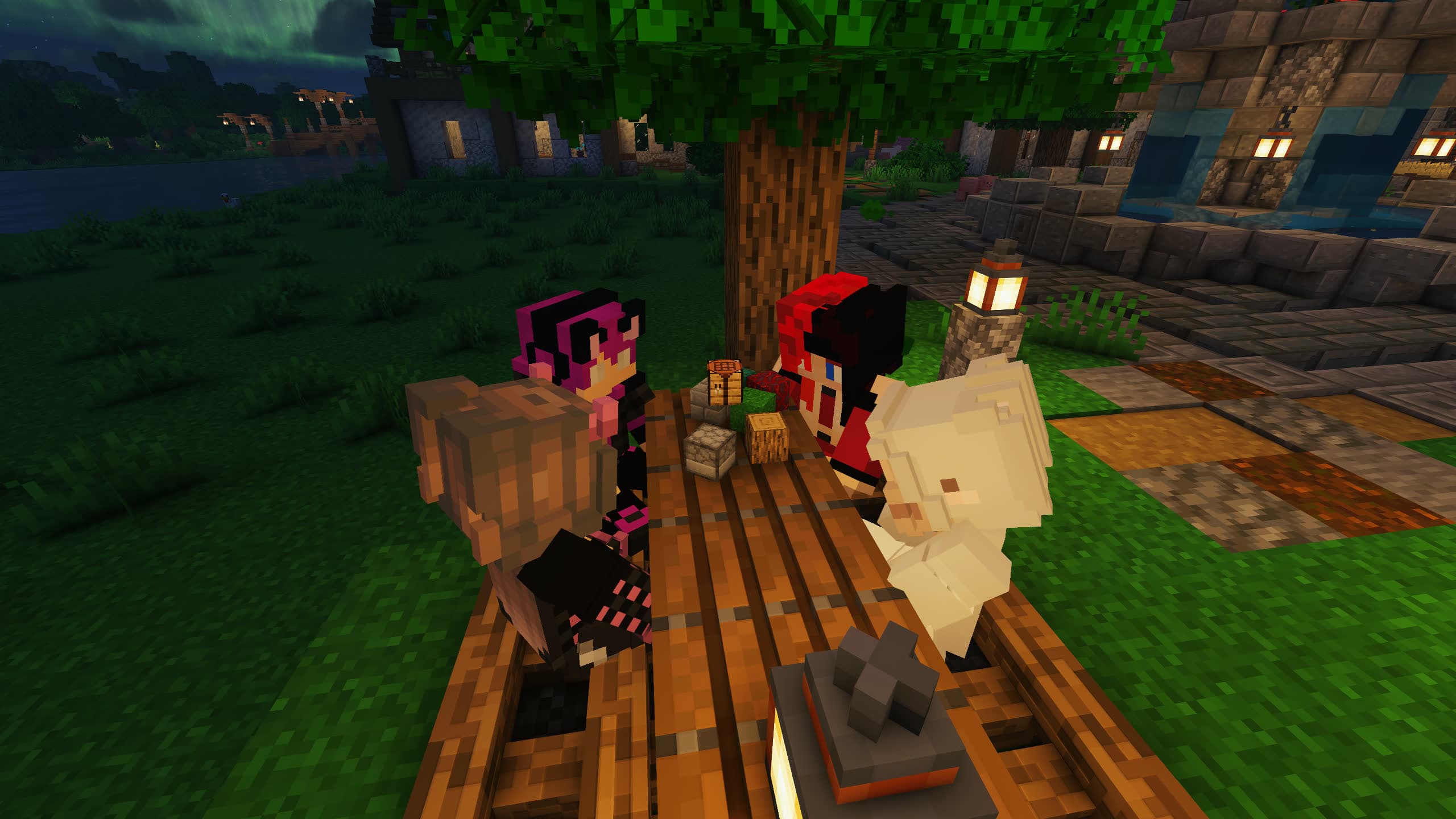 Four players sitting together at a table under a tree at night